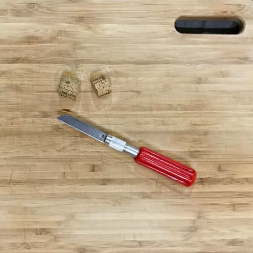 Cut wine cork in half with whittling blade