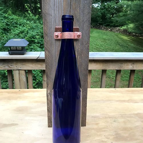 bottle inserted into collar of hardware for wine bottle vase