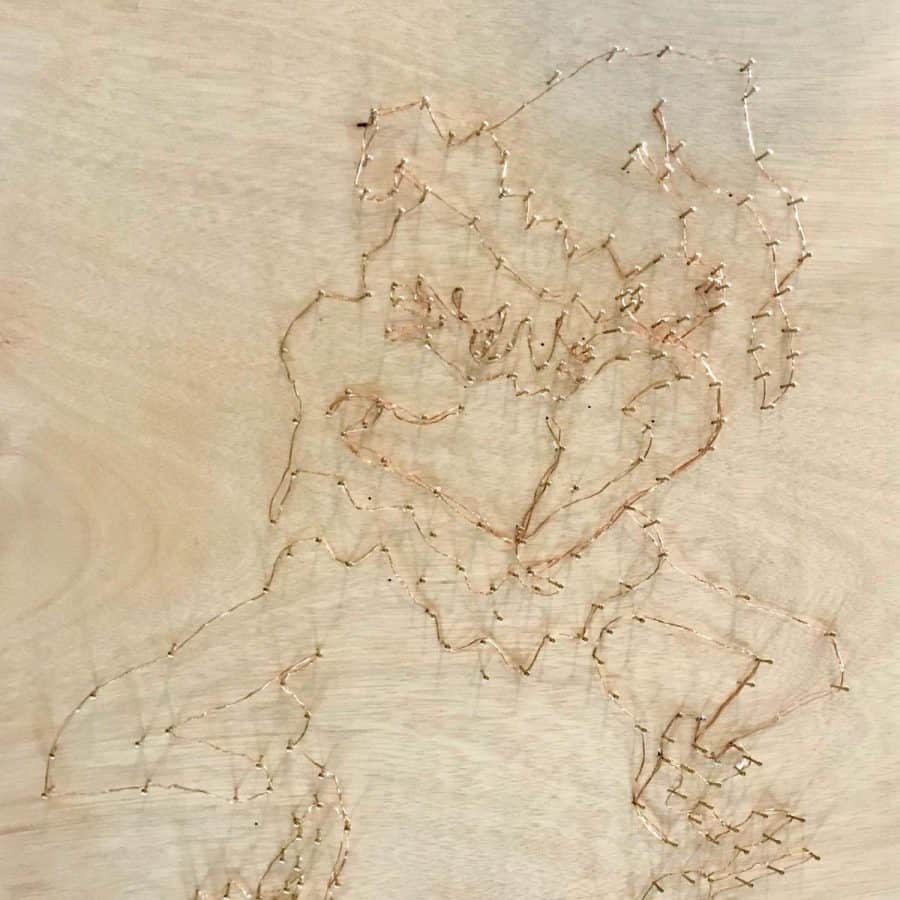 nails hammered into plywood of grinch shape