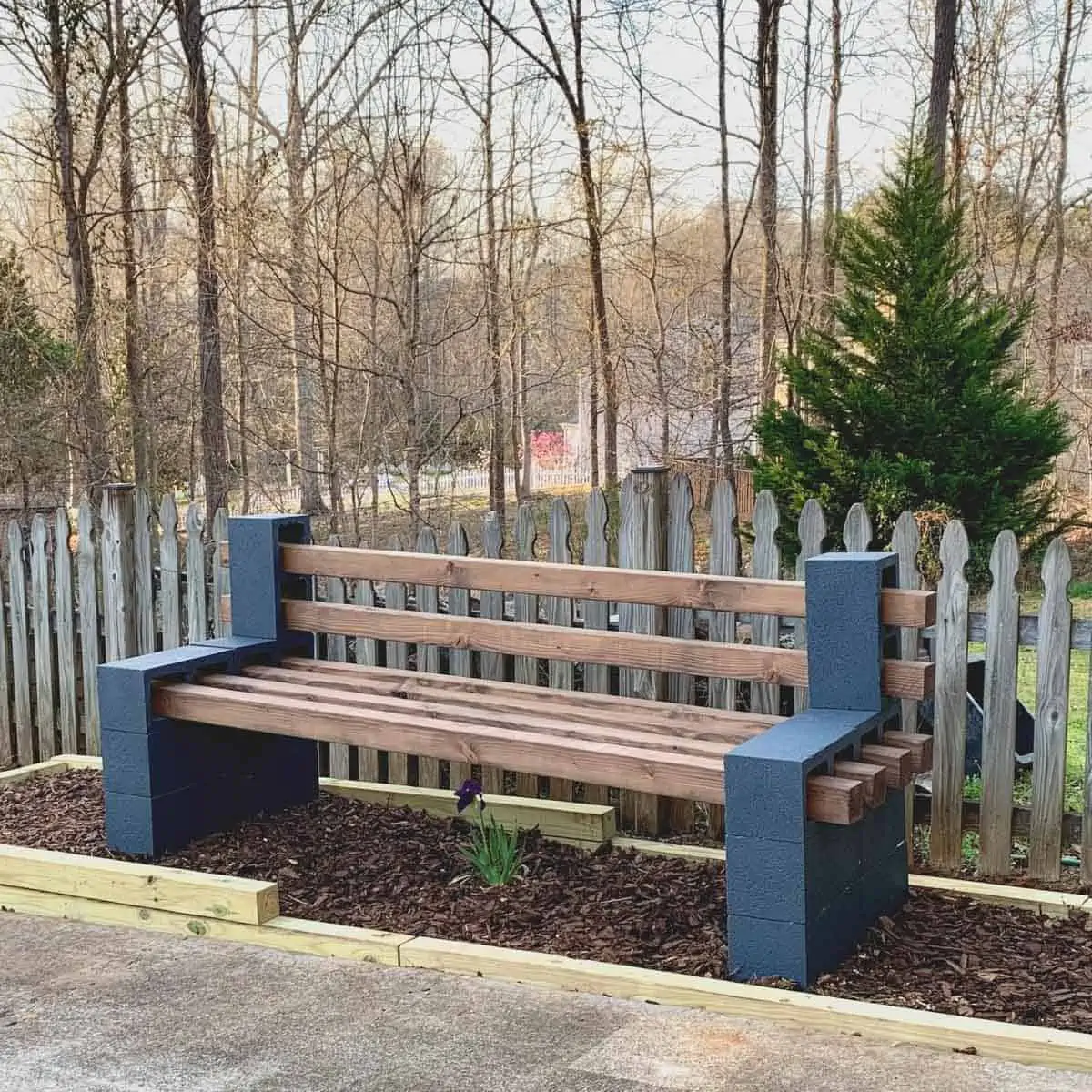 diy conceder block bench sitting in raised garden bed