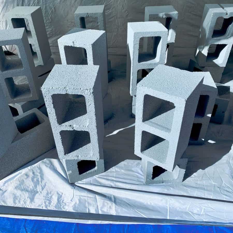 cinder blocks standing on ends with white primer on them