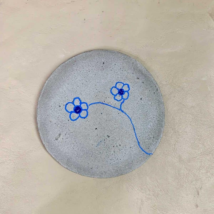 diy concrete coasters with flowers drawn and center blue resin