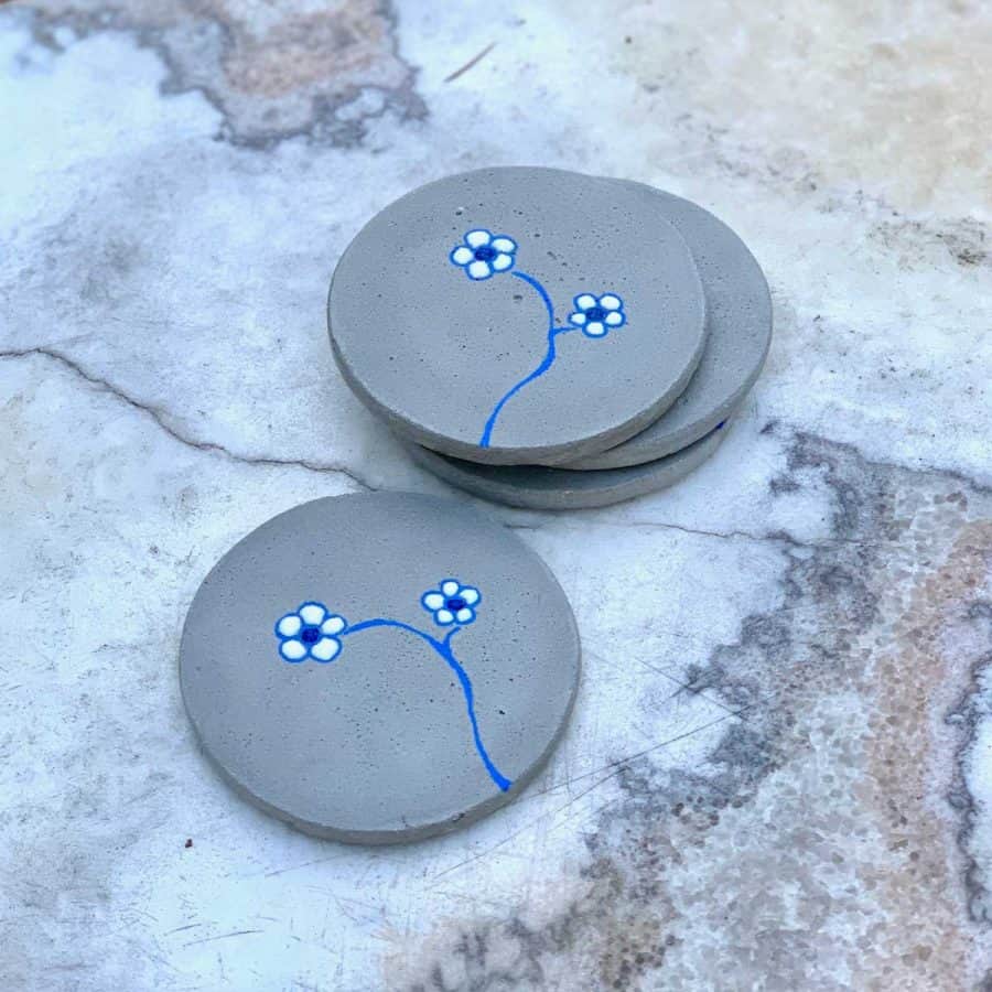 concrete coasters with flowers on them on a stone bench
