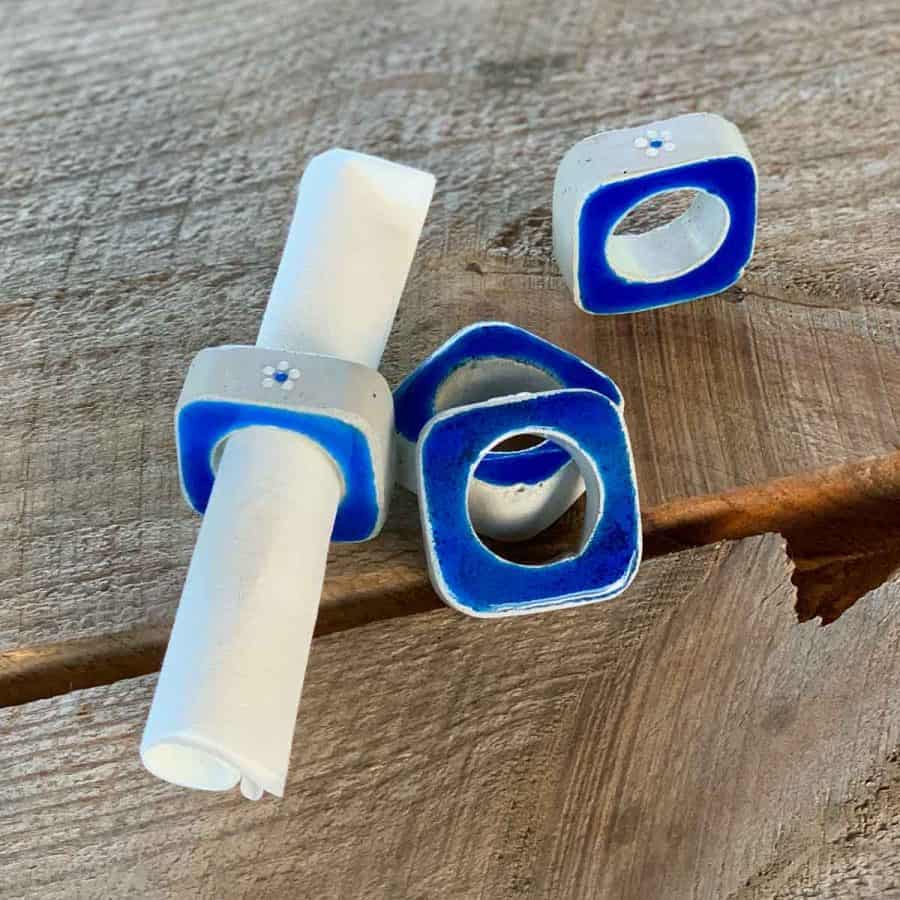 concrete napkin rings with bright blue resin on wood dining table
