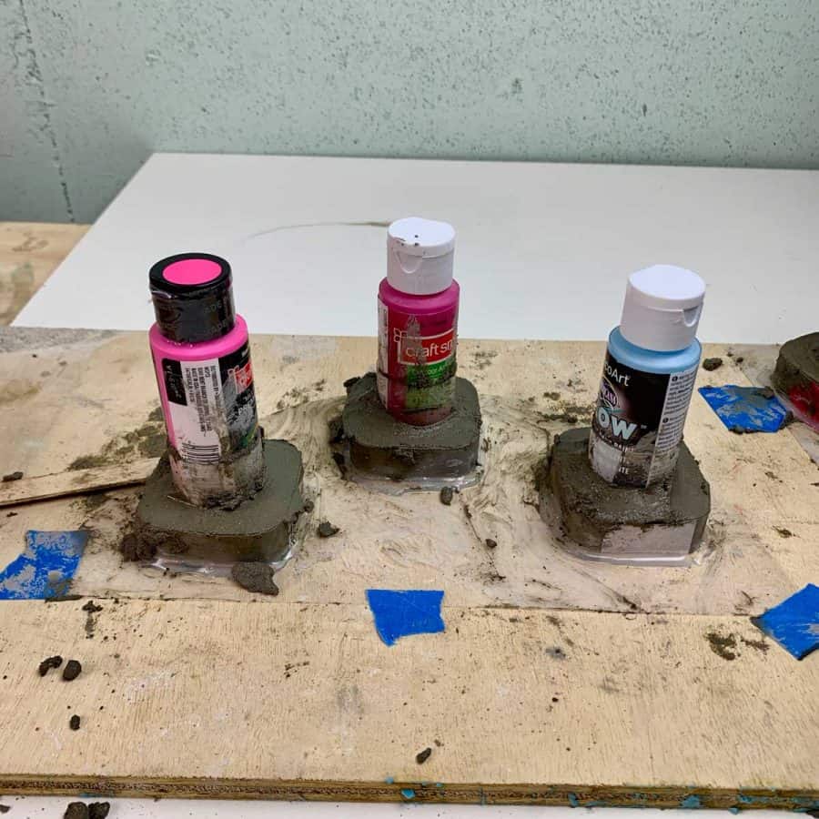 concrete filled inside of diy napkin ring holders, with paint bottles inserted