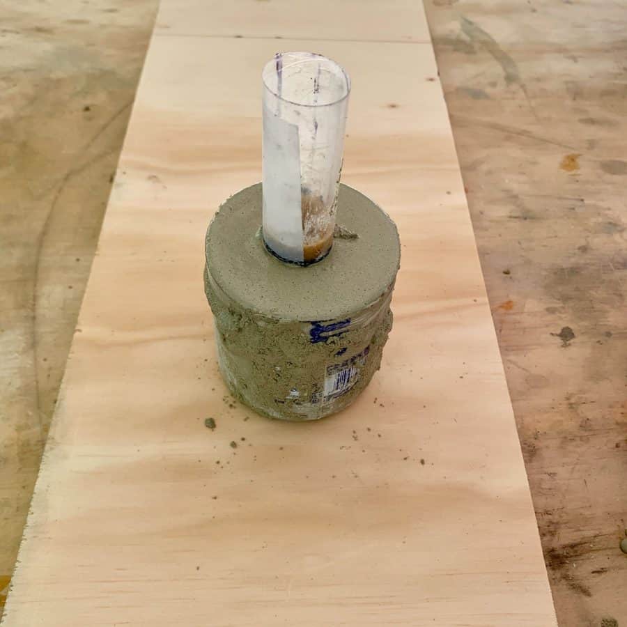 cylinder inserted in concrete within DIY candlestick holder mold