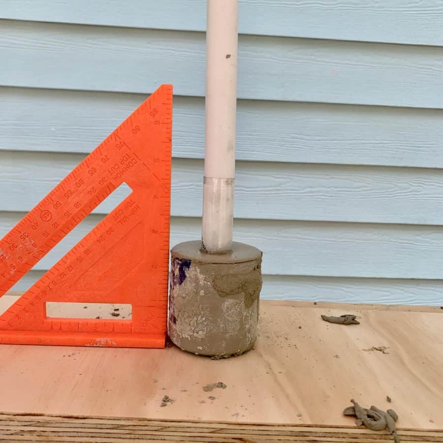 squaring tool showing plumpness of candlestick inside of cement