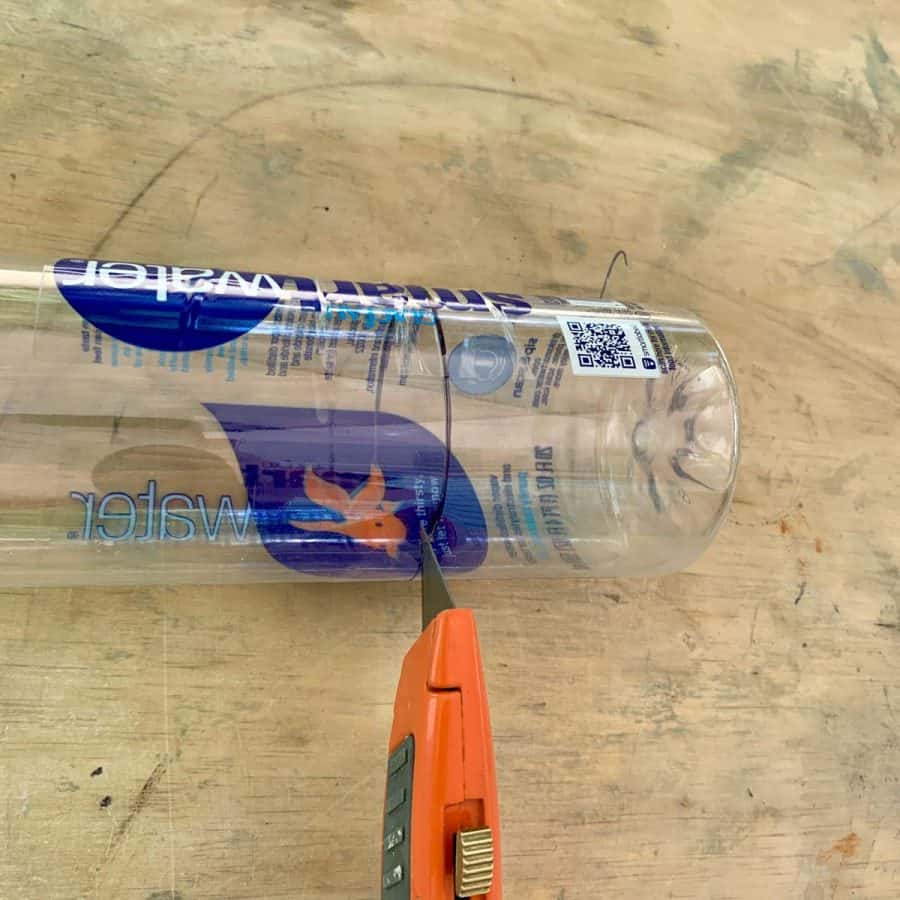 smartwater bottle being cut with box cutter at line