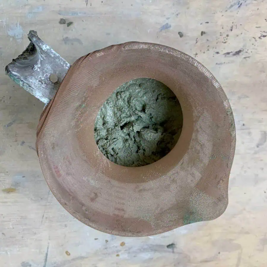 colored concrete mix inside of a stocking over a cup