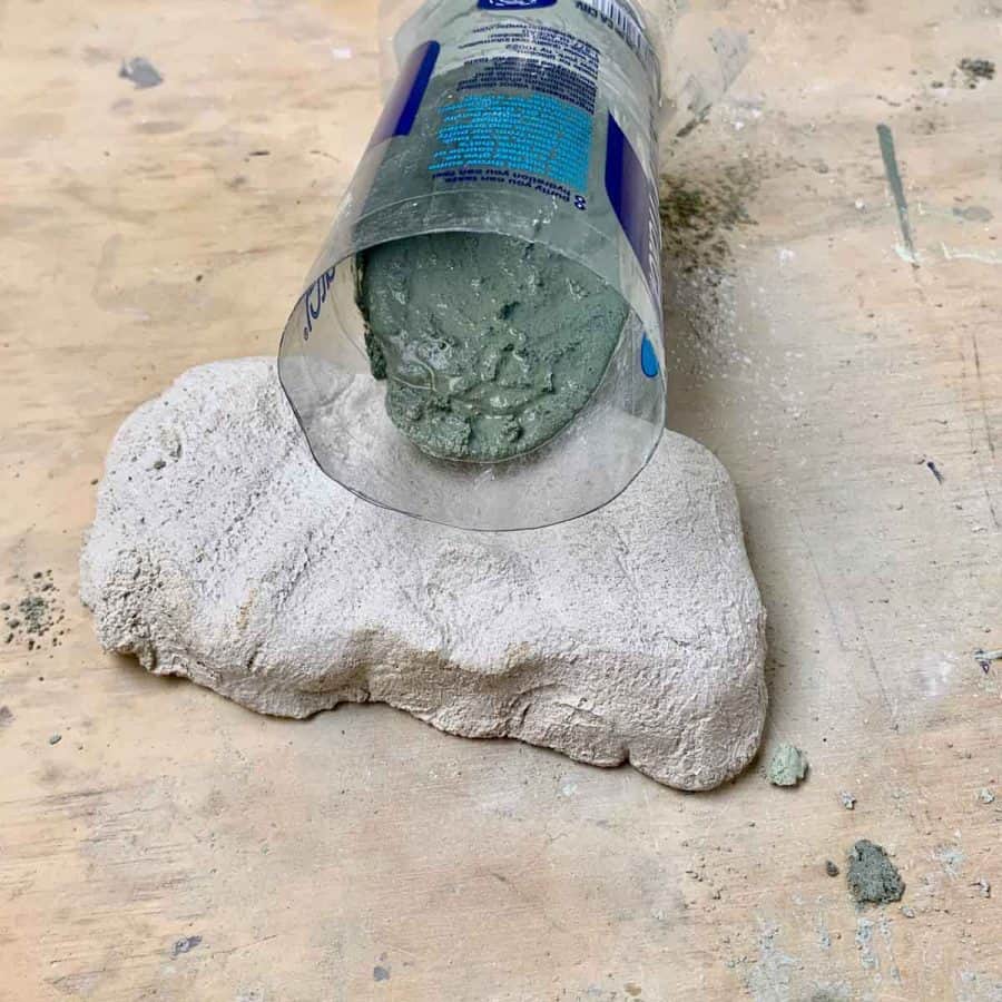 bottle on it's side with green concrete spilled at angle