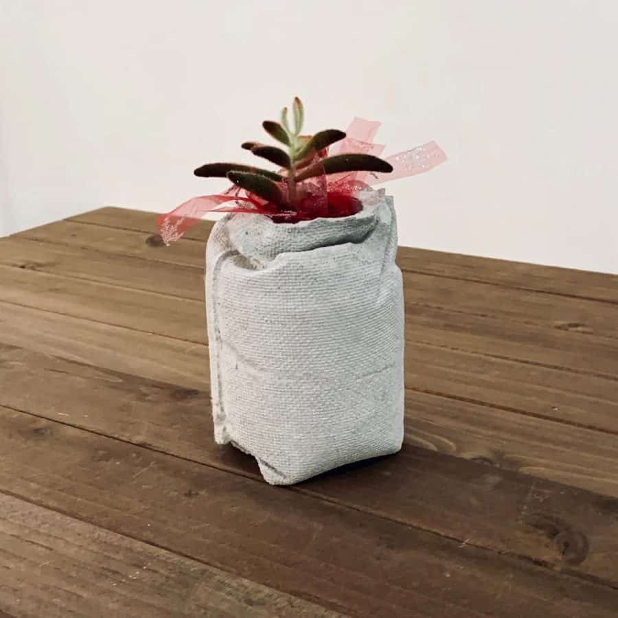 planter that looks like a burlap bag on wood planks