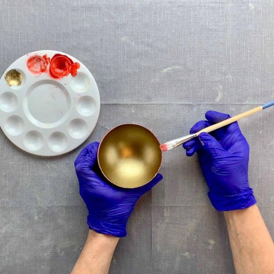paint brush touching top edge of gold painted diy mini concrete bowl