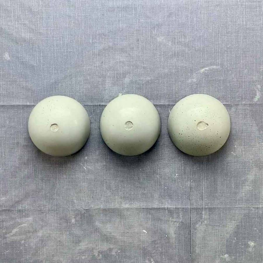 3 concrete diy mini bowls upside down with clay removed, showing flat recess
