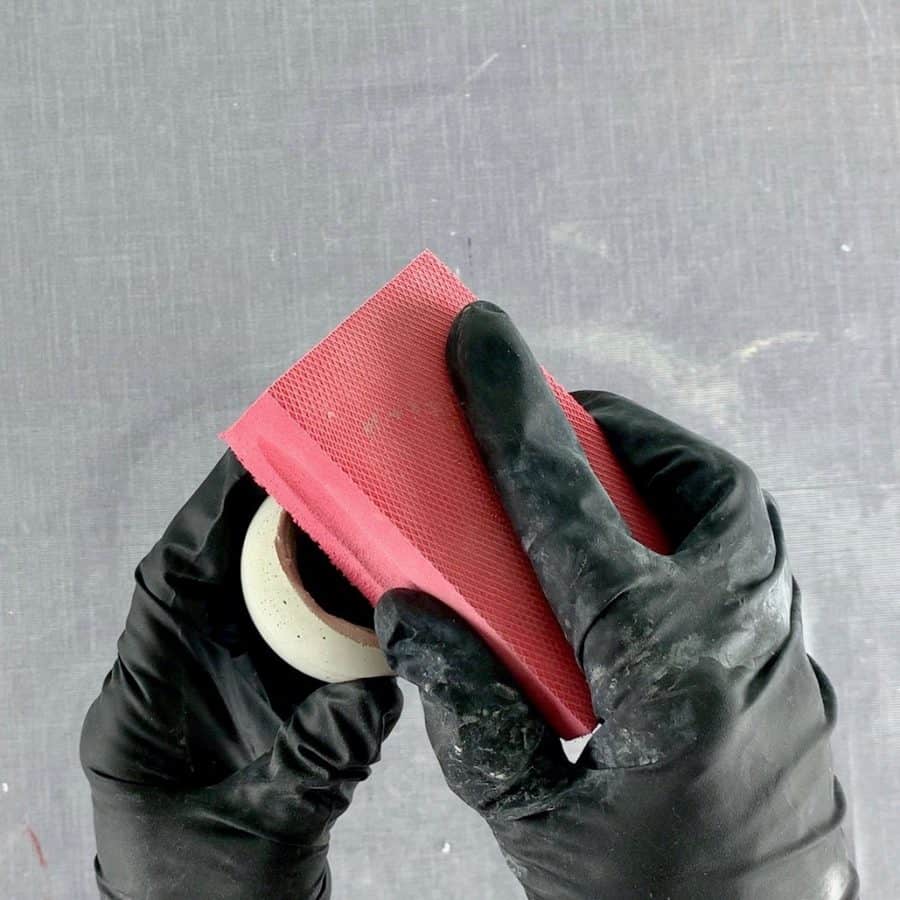 sanding concrete with durable gloves on