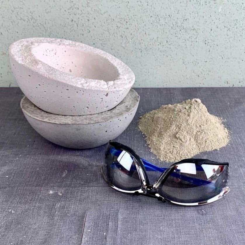 safety glasses, pile of dry cement mix and concrete bowls