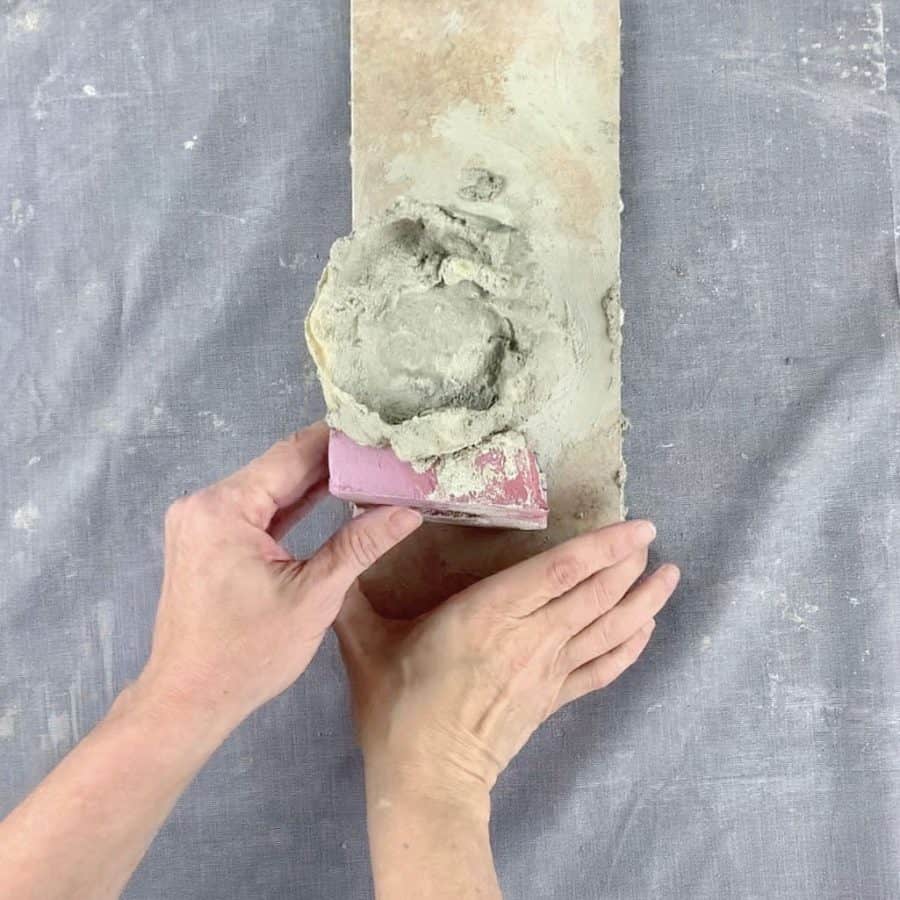 hand placing pink foam under toe of casted mold