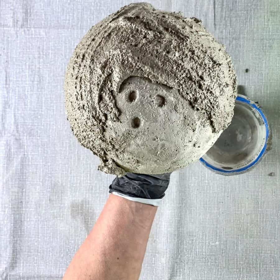holding cement balloon bowl with 2nd layer of cement slathered on
