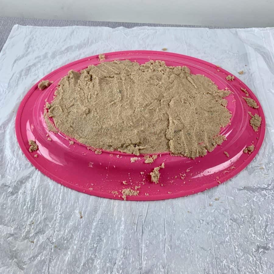 tray upside down with sand piled on top