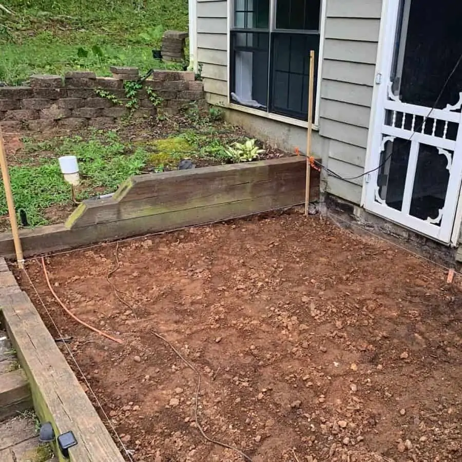 concrete paver patio area with stakes in ground with string tied between two
