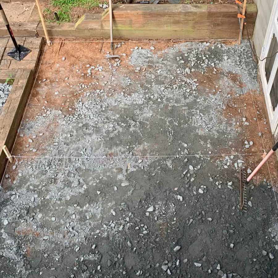 full patio area with sgravel on top and stakes around it with strings tied around and in between middle of patio