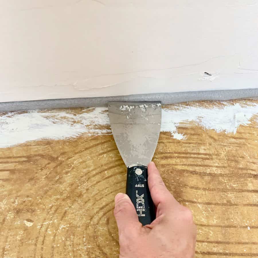 level concrete floor- spackle knife pressing foam backer road under drywall