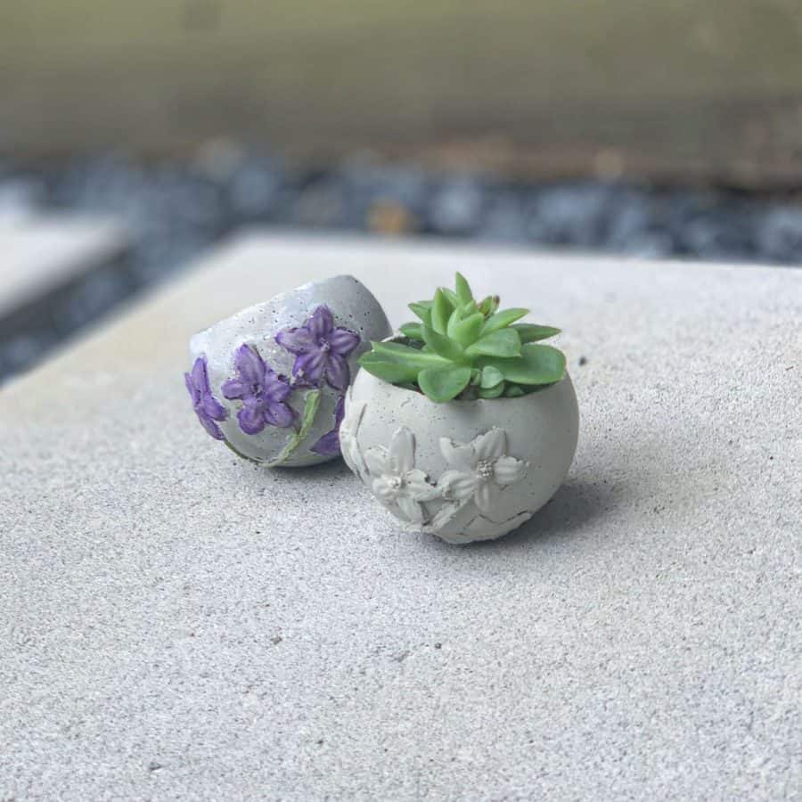 Silicone Sphere Mold- two concrete planters that are round, have botanical imprints, made from silicone mold
