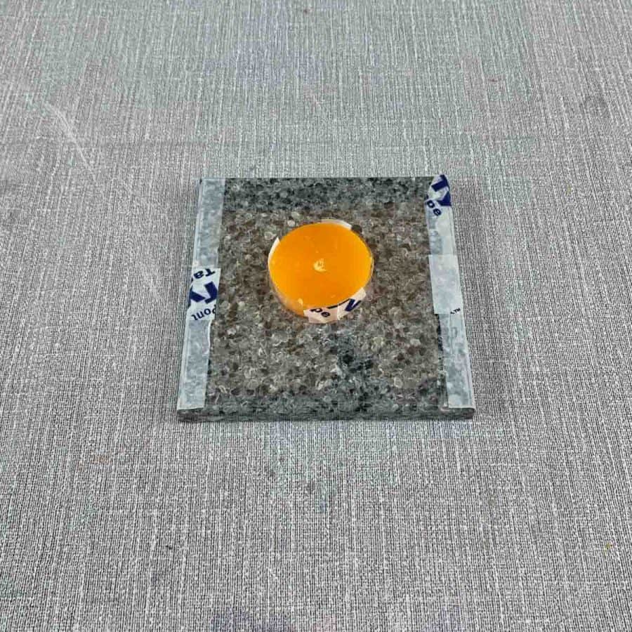Concrete Candle Holder- tile with acetate sheet taped to bottom and candle glued in center.