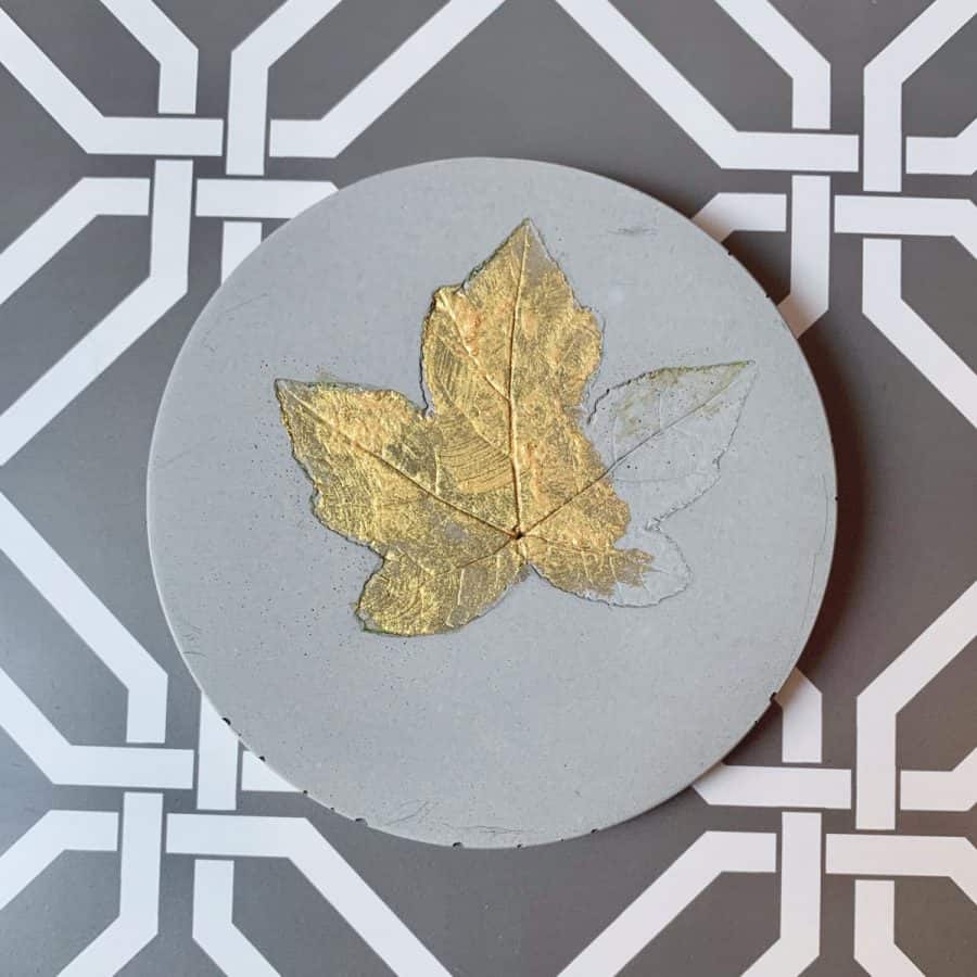 Concrete Coasters- coaster with leaf and partially painted with gold paint.