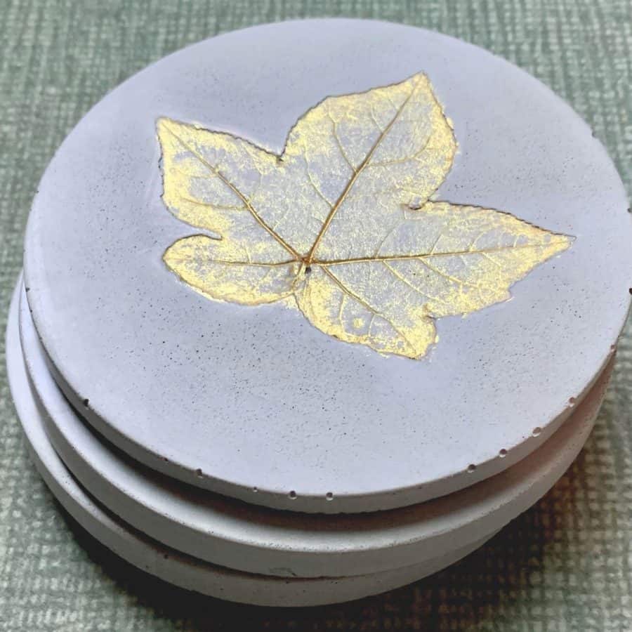 Concrete Coasters-Concrete Coasters- stacked with sweet gum tree leaf imprint, painted gold.