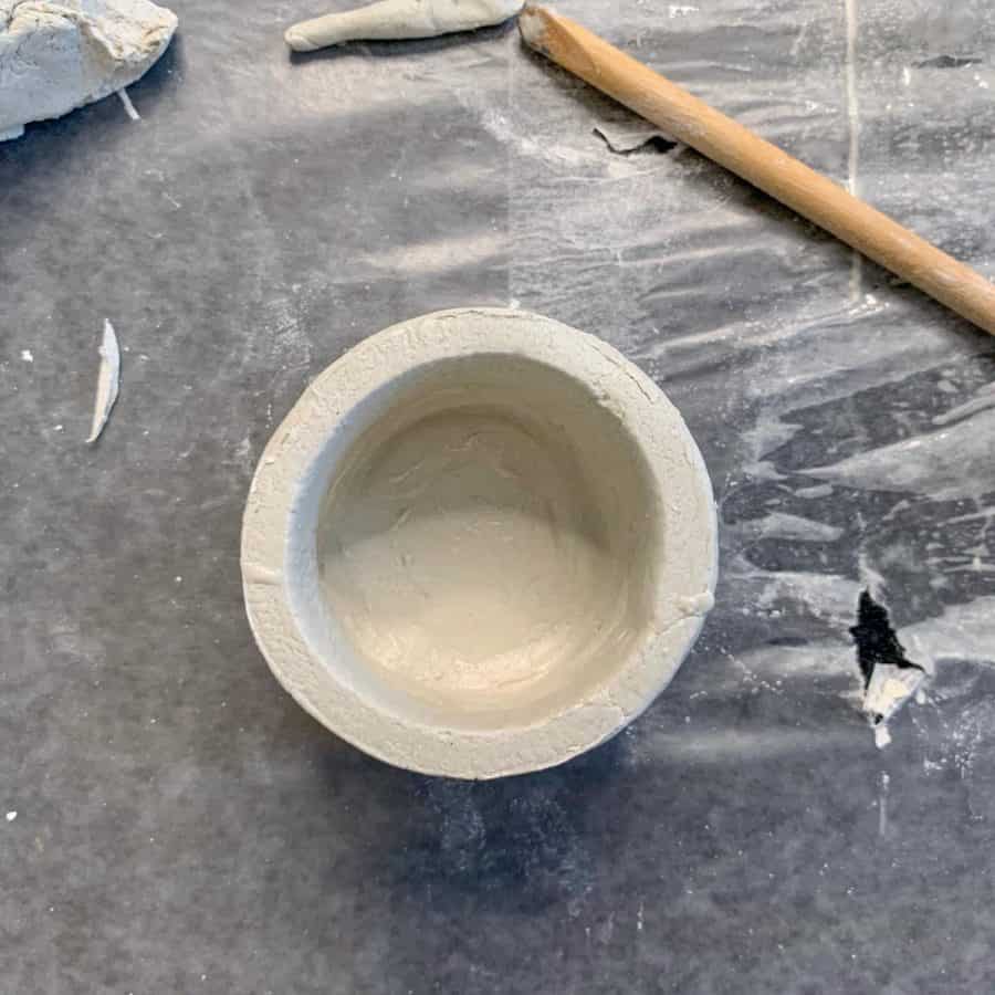 inside bottom of air dry clay candlestick holder with base smoothed