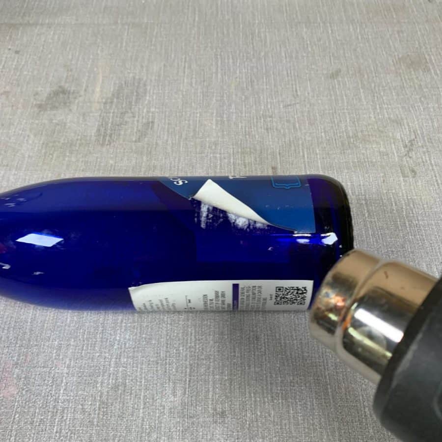 heat gun blowing air on bottle