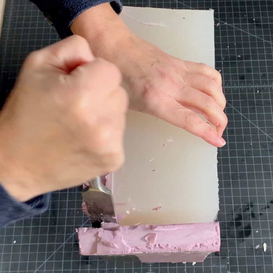 chisel prying sides away from cured silicone mold
