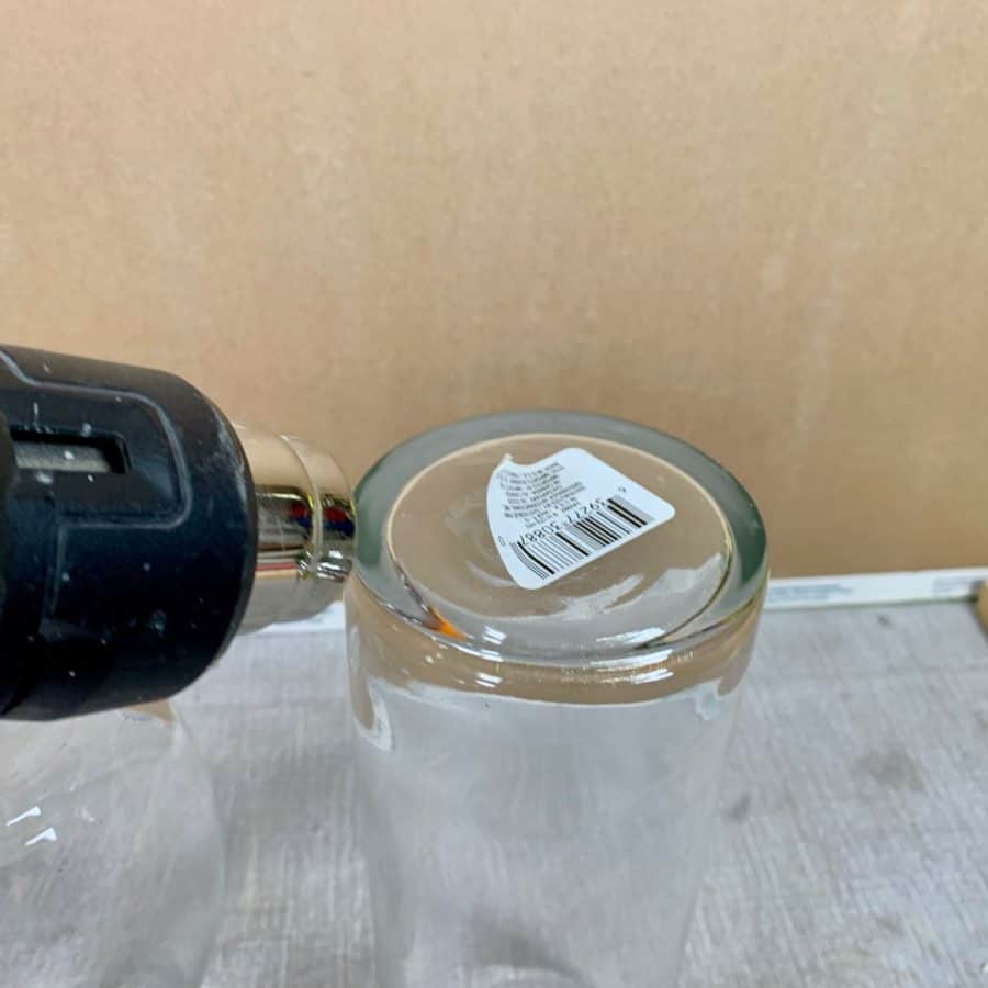 heat gun blowing air on label stuck to glass vase