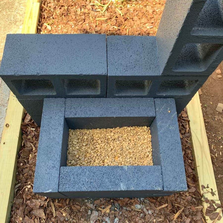 concrete planter box with gravel covering half of bottom