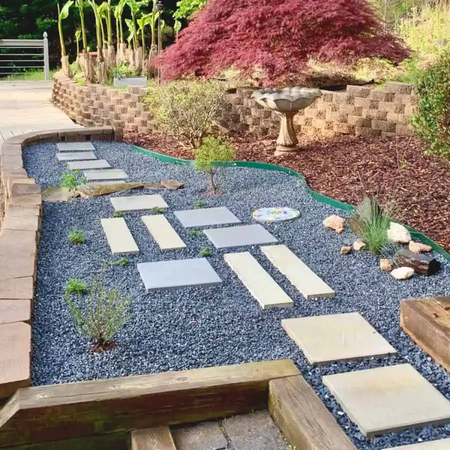 finished gravel garden with stepping stones of various shapes and colors and plants weaved in between and around them