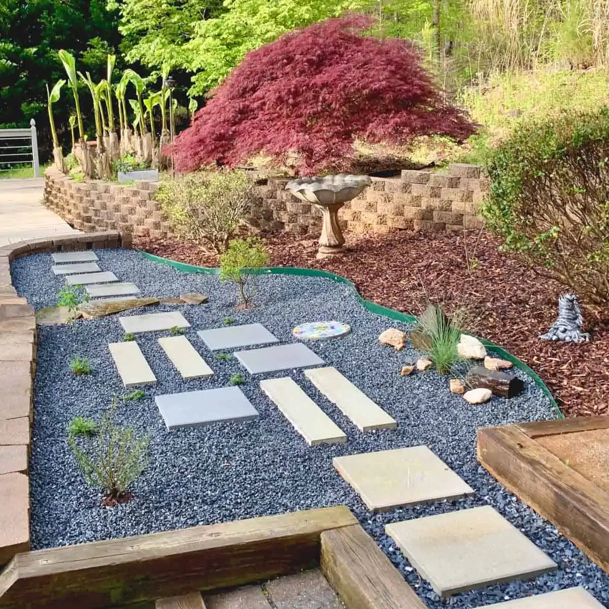 finished gravel garden with stepping stones of various shapes and colors and plants weaved in between and around them