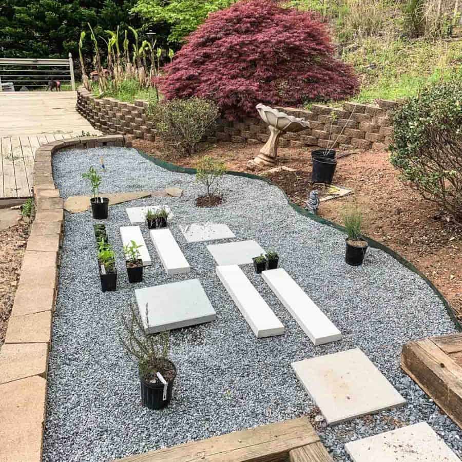 gravel garden bed with pavers laid on top and plants arranged in designed locations