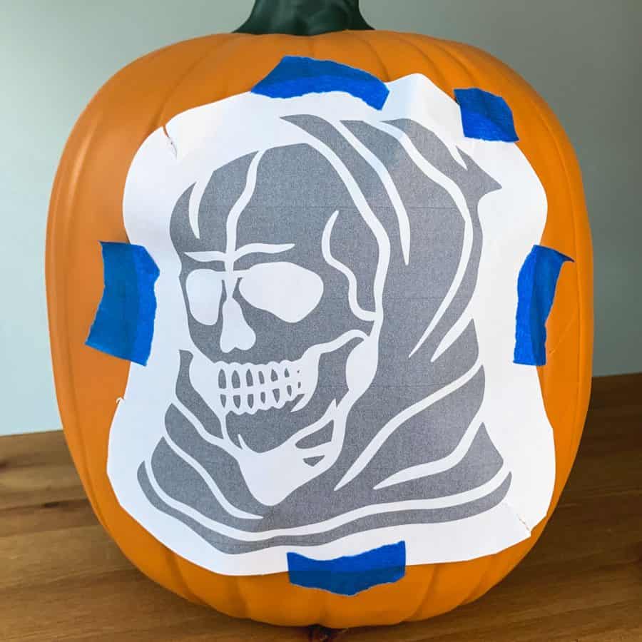 pdf pumpkin pattern of a skull taped to a pumpkin