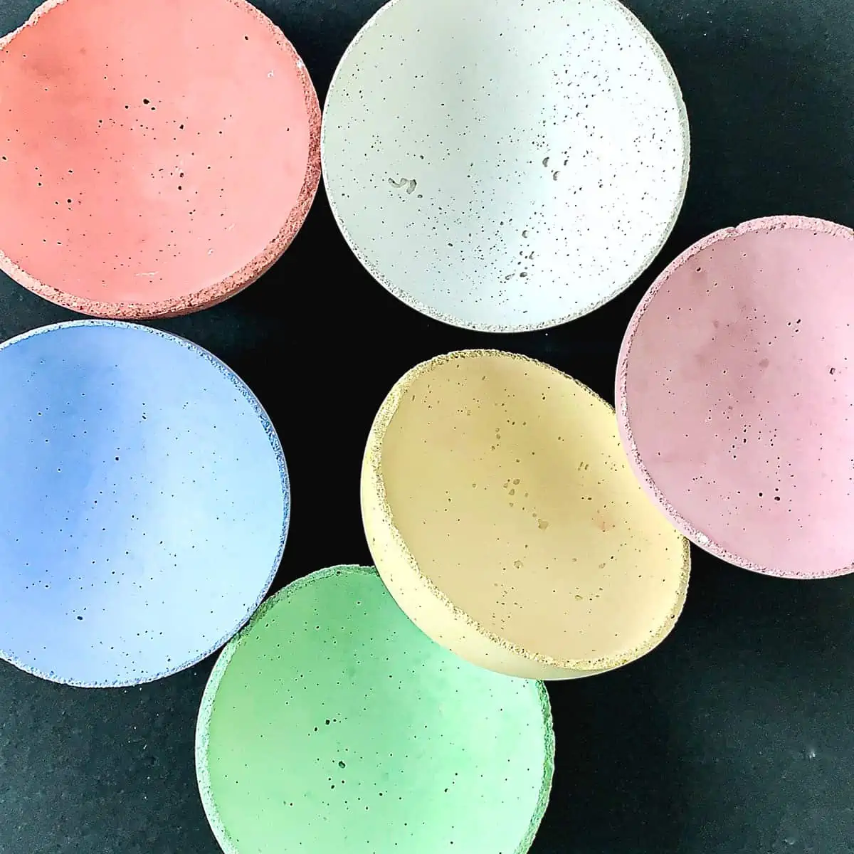 multiple bowls in a variety of colored concrete on a table