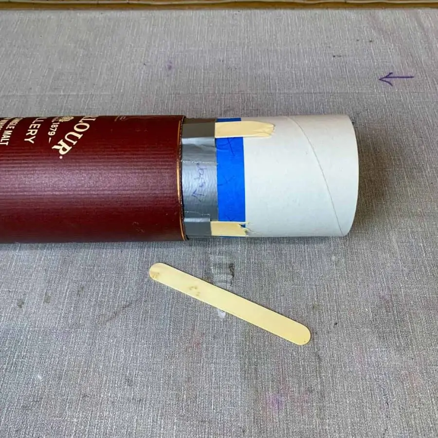 2 tubes attached by duct tape with craft sticks shimmed between