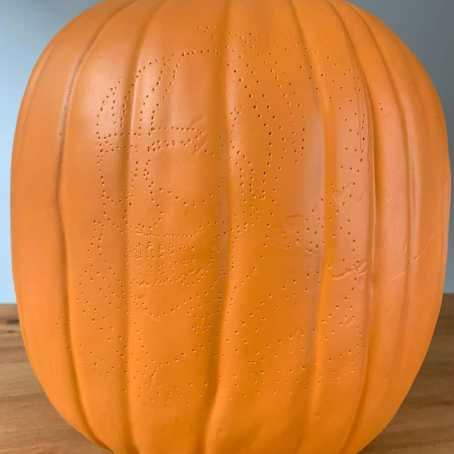 pumpkin with thumbtack holes showing outlines from pattern