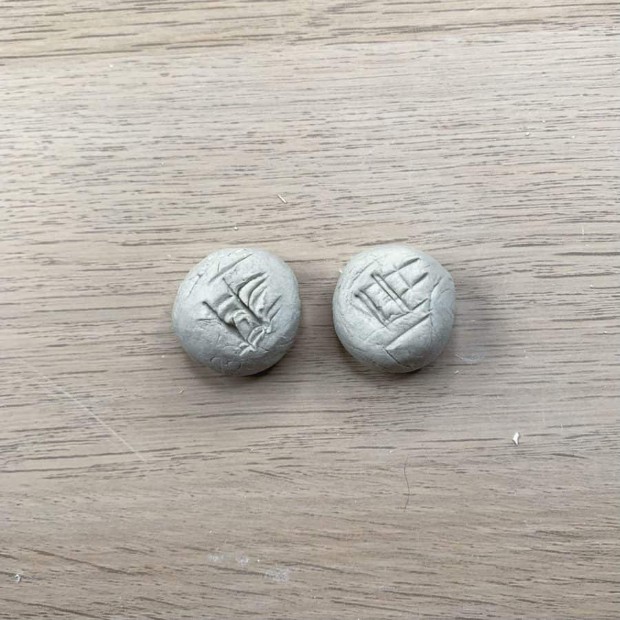 two balls of clay with hatch marks across and wet