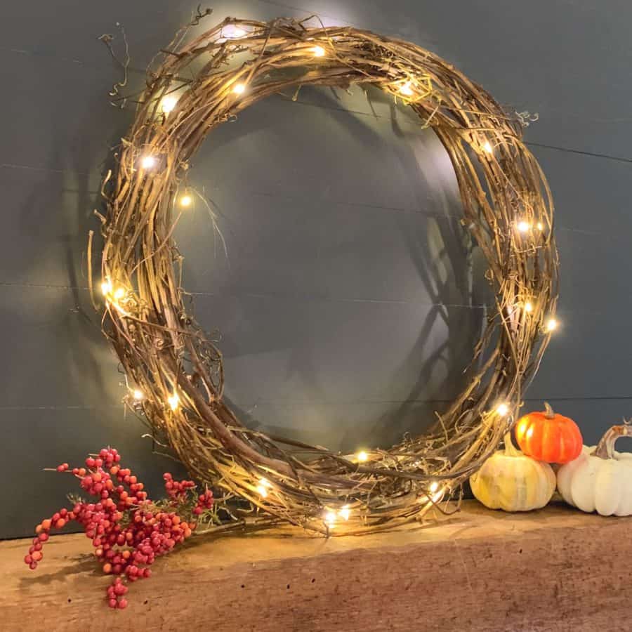 finished grapevine wreath with lights on a mantel