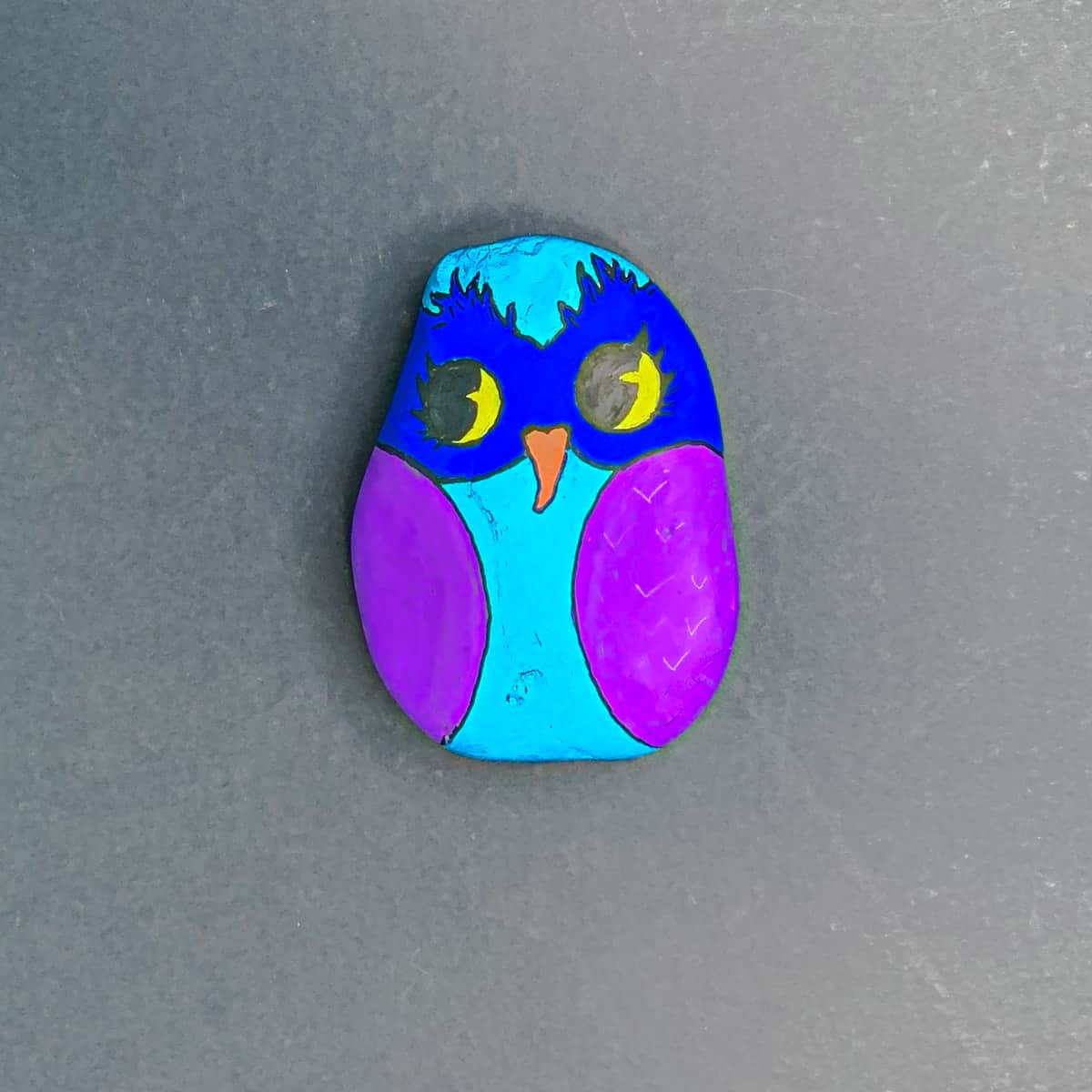an owl painted on a rock with pupil details colored in