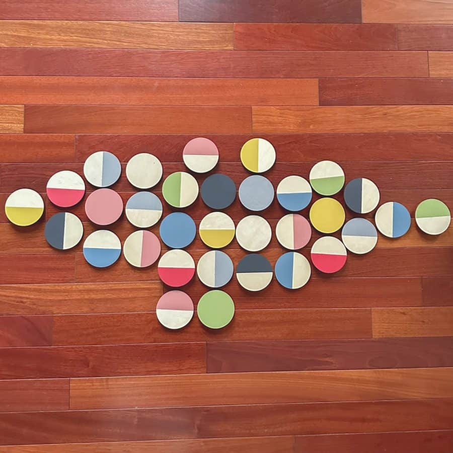 Painted wood wall art discs arranged in pattern as they will go onto the wall.