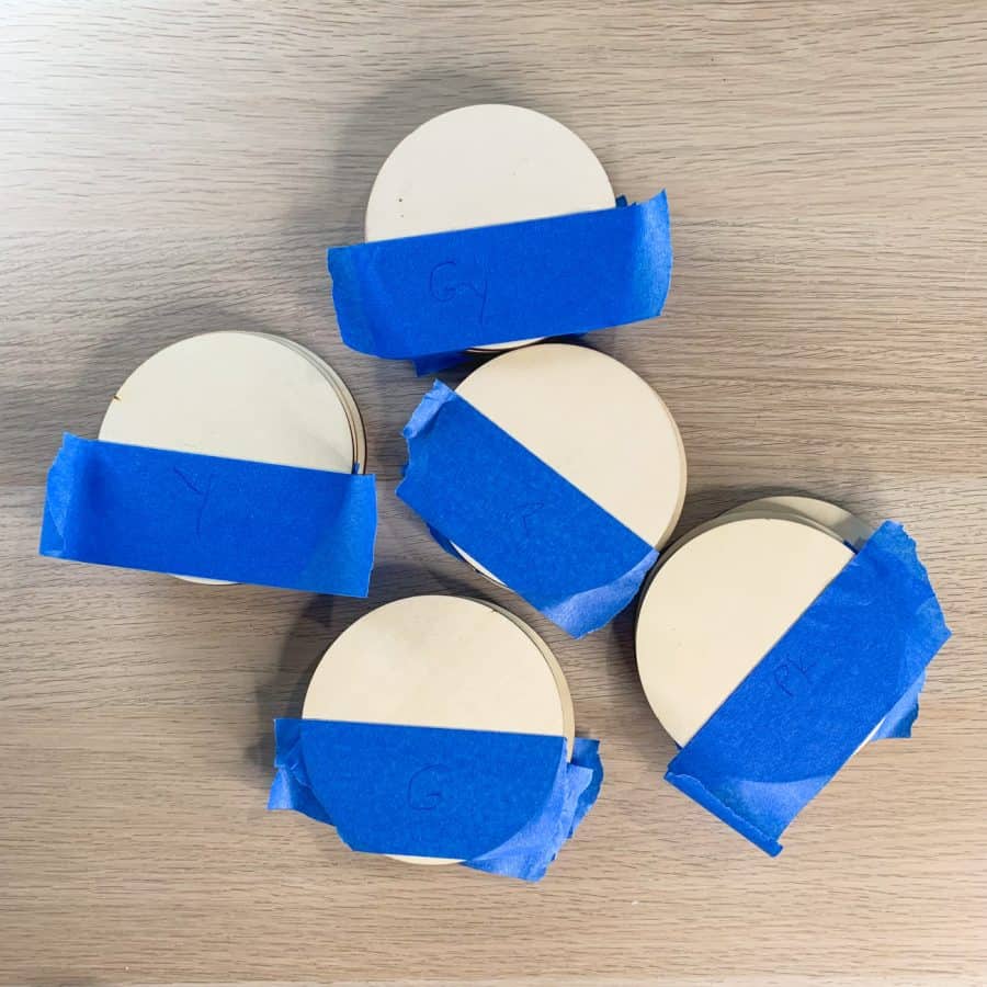 wood circles stacked with blue tape on top and labeled by color.