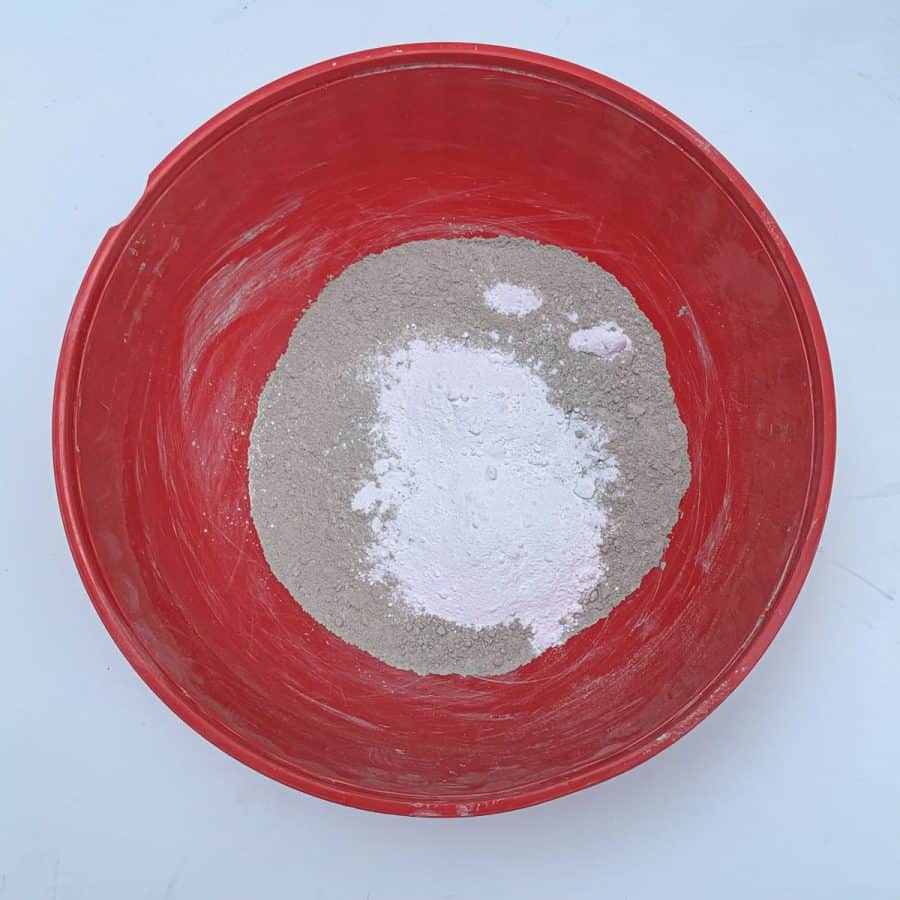 A bowl with tan colored cement and white powder in the middle.