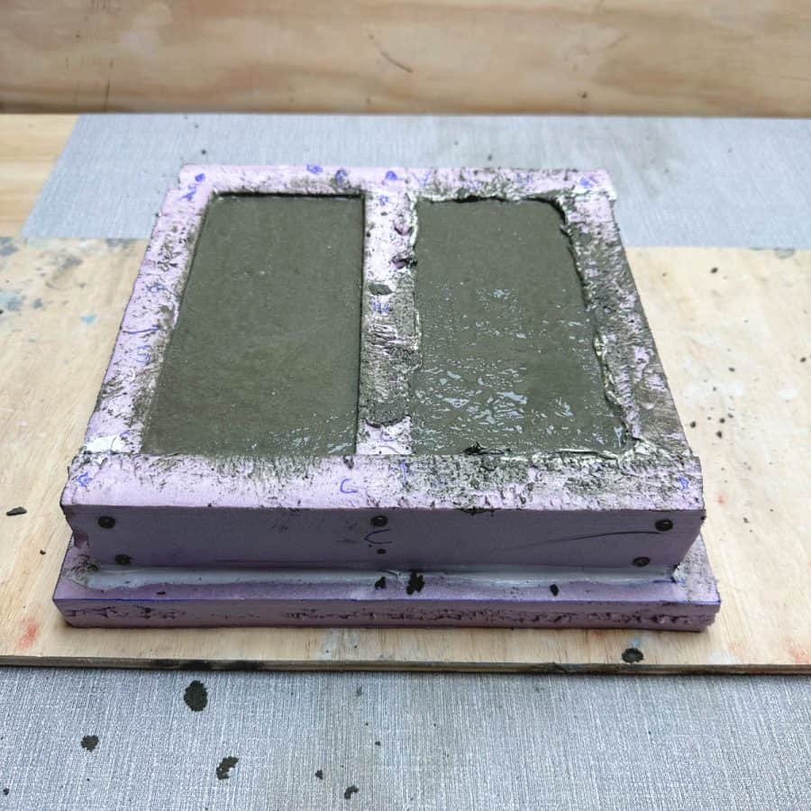 Bricks mold with wet concrete mixture filled to top.
