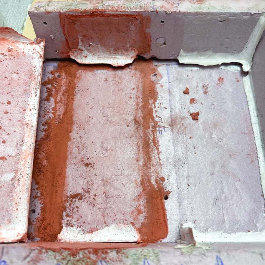 Inside of DIY concrete bricks mold with silicone caulk not intact with base piece.