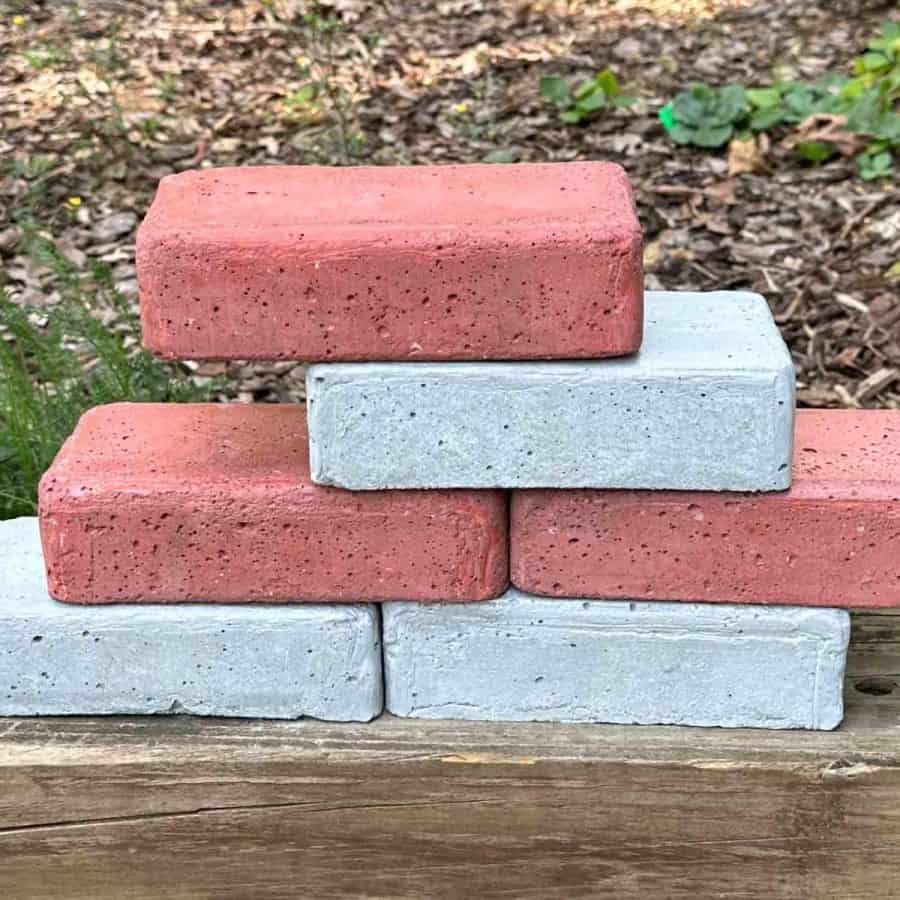 DIY concrete bricks stacked on some wood in a staggered pattern.